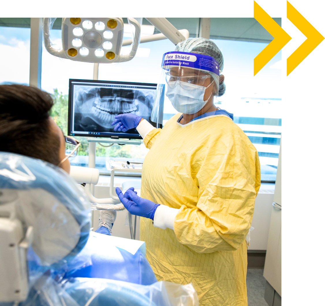 Dental student showing x-ray on screen to patient