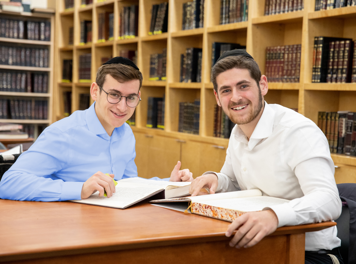 Two LCM students smiling at a table