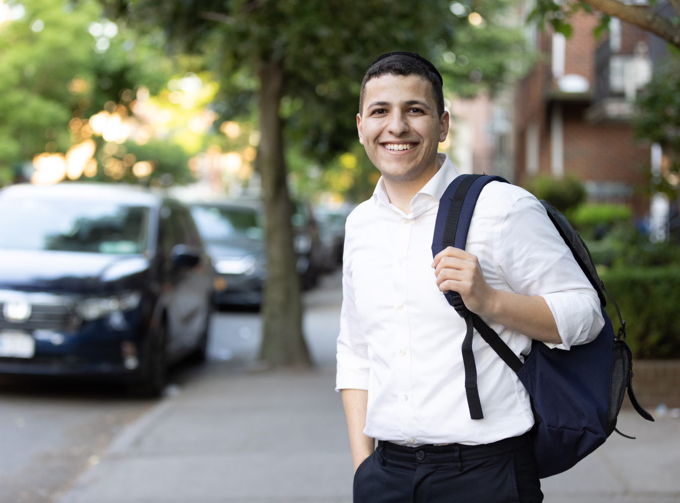 Male student smiling on sidewalk