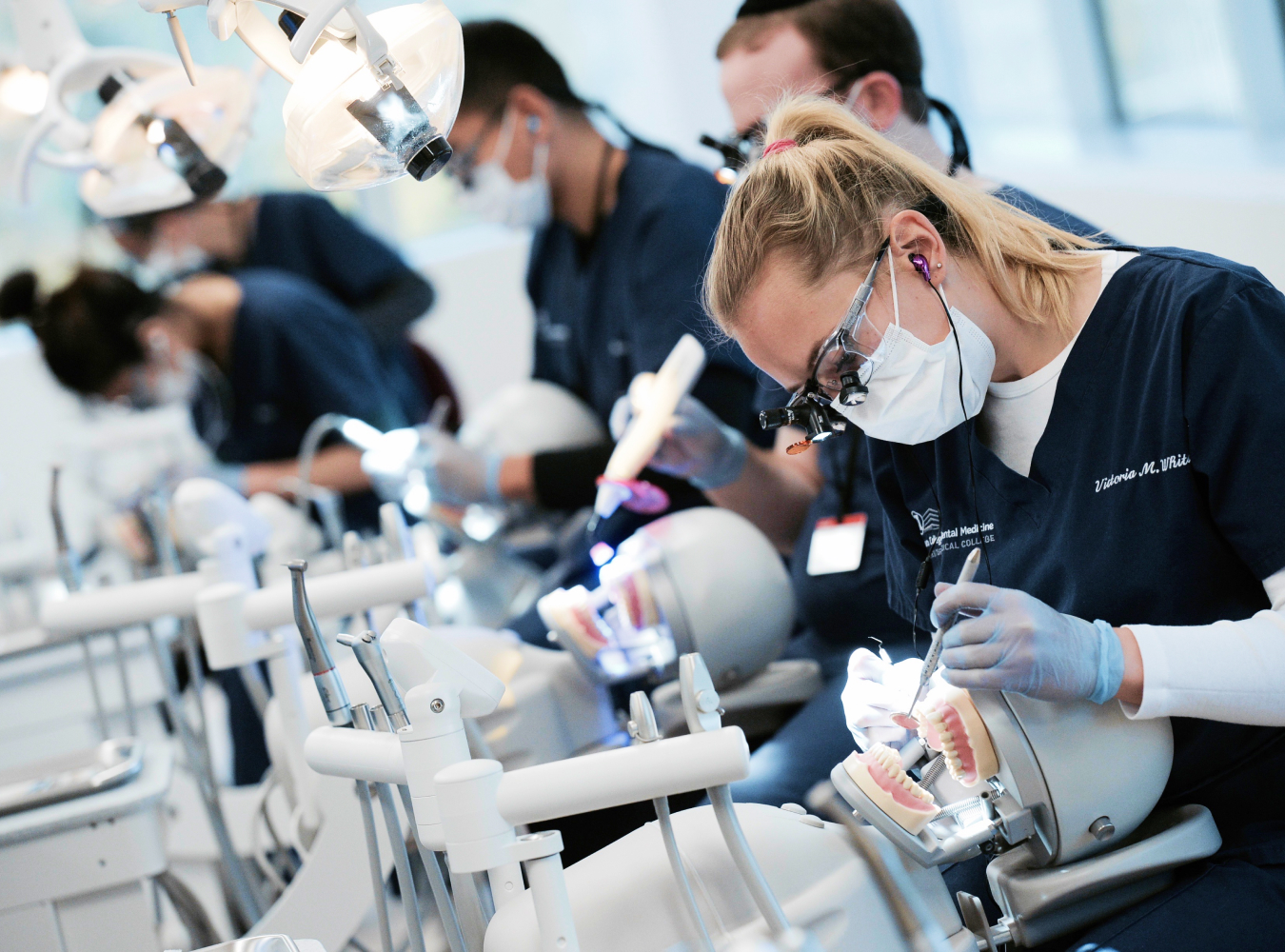 Dental students practicing cleaning teeth in lab