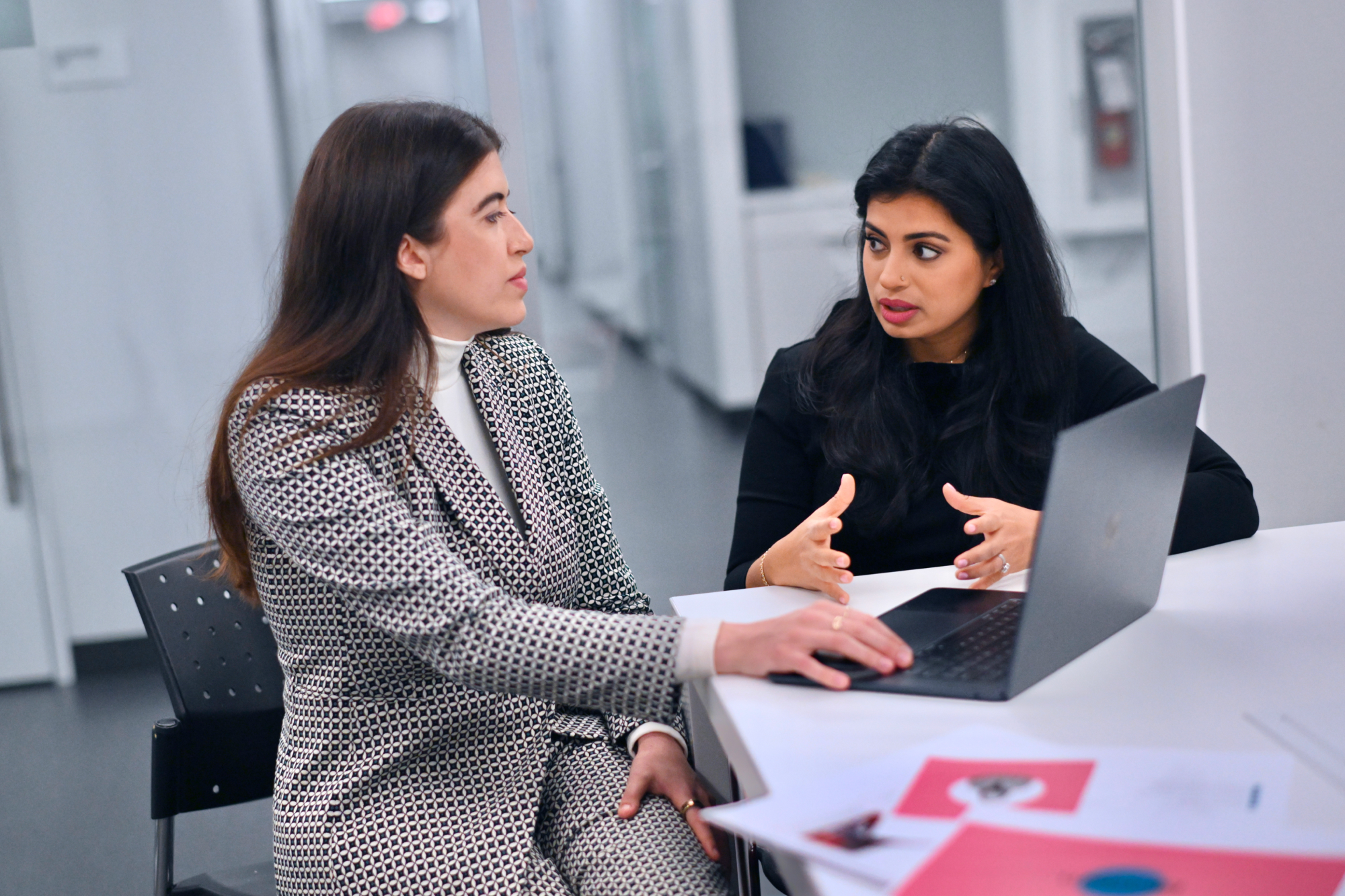 Two students having a discussion at a table.