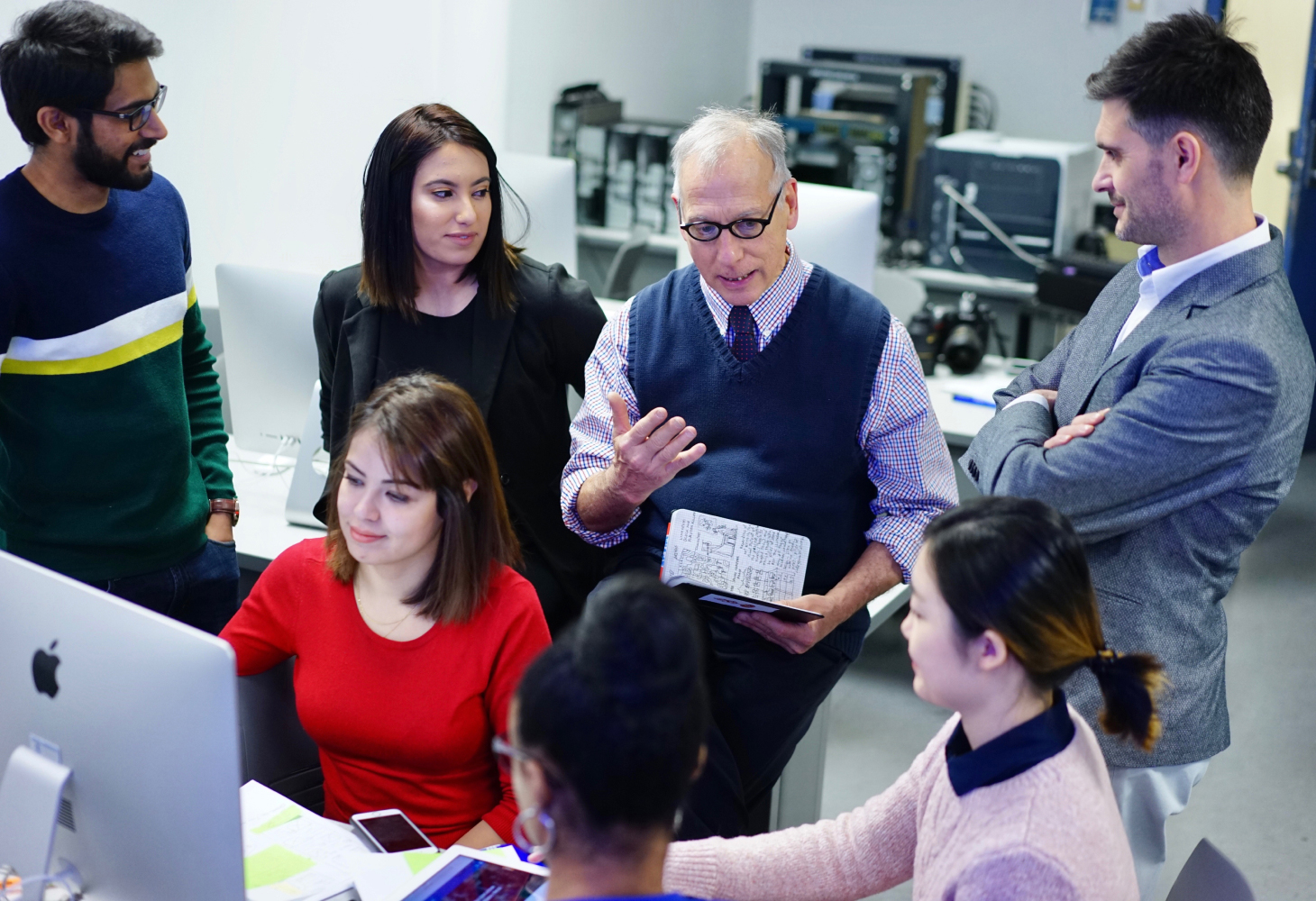 Male professor teaching a group of students at GST.