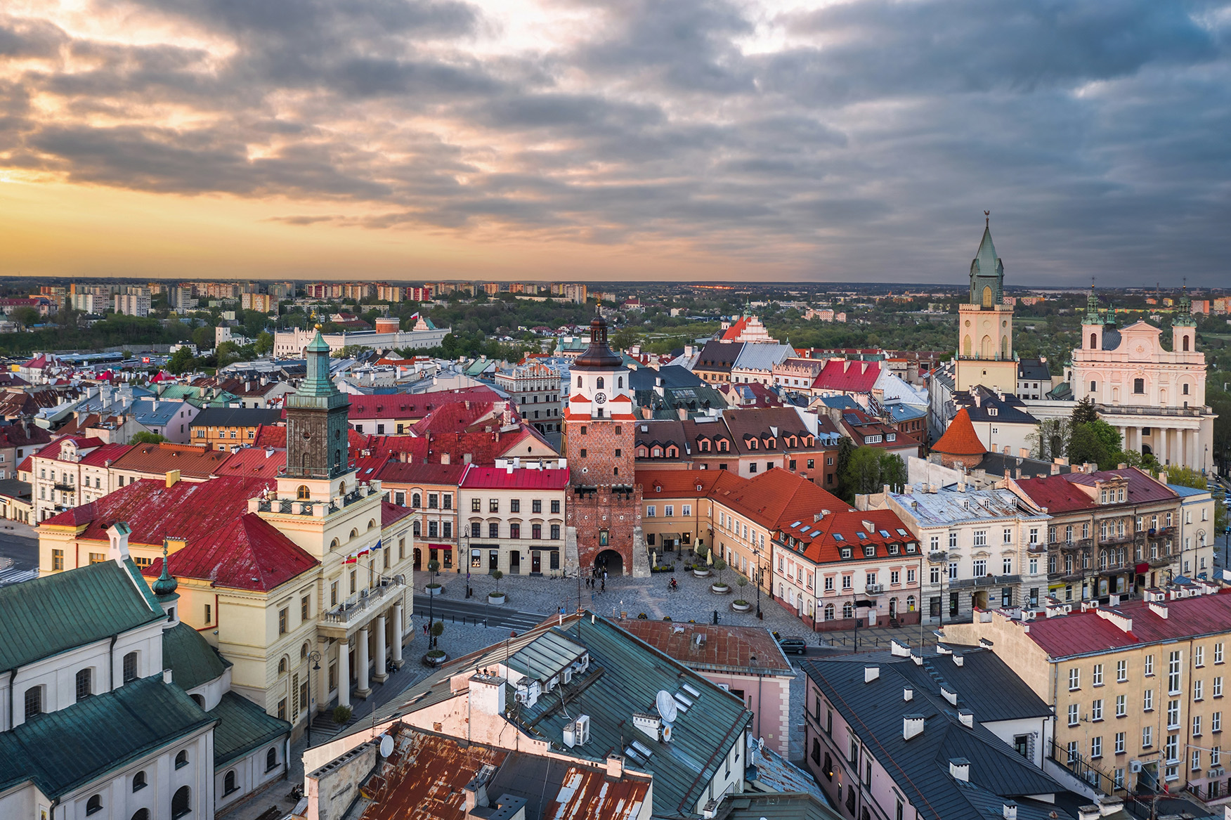 Aerial view of Królewska street and the old town landmarks at sunset: Cracow Gate (Brama Krakowska), Town hall (Ratusz), Cathedral