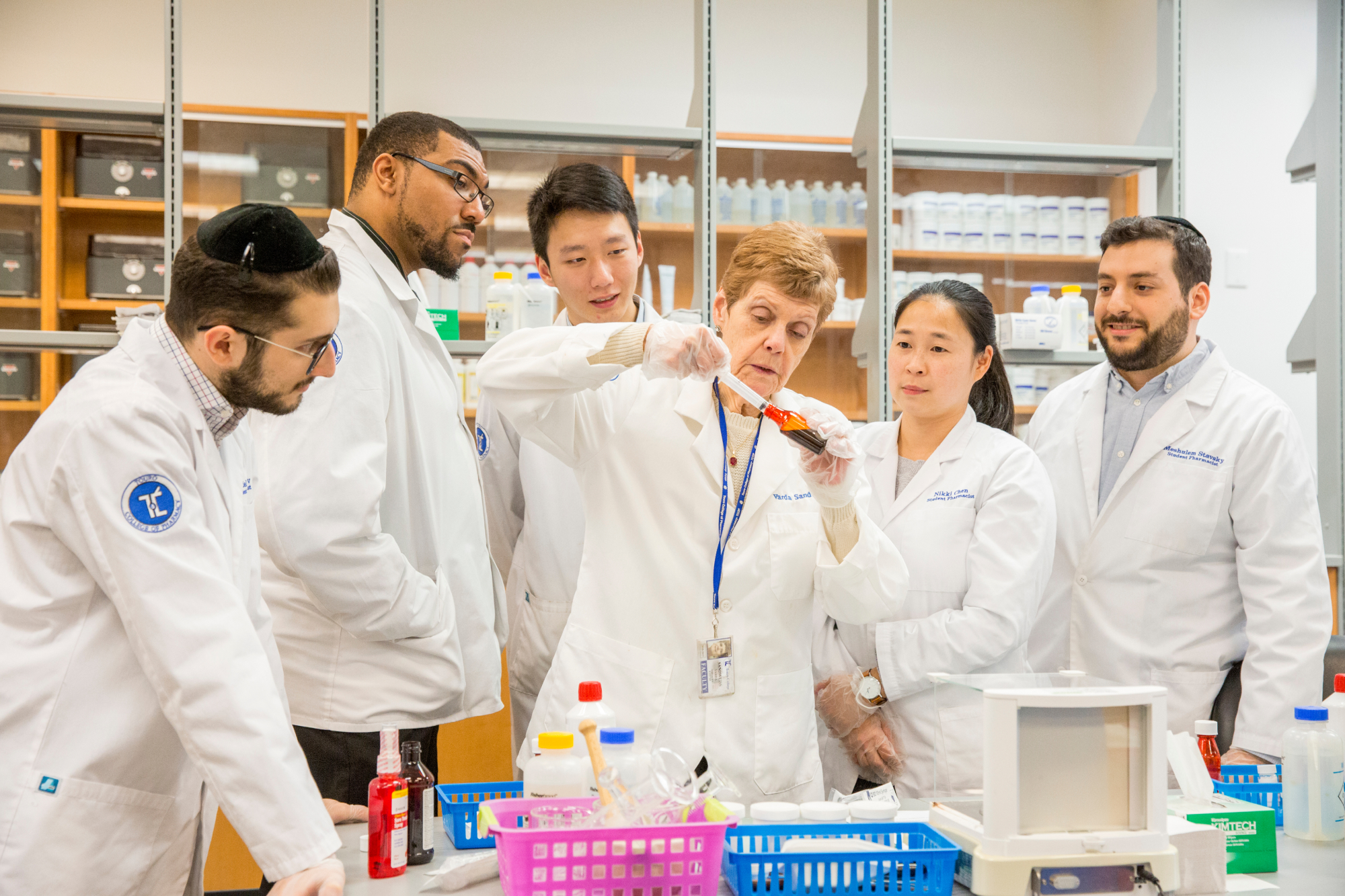 Female professor teaching a group of students in dental lab