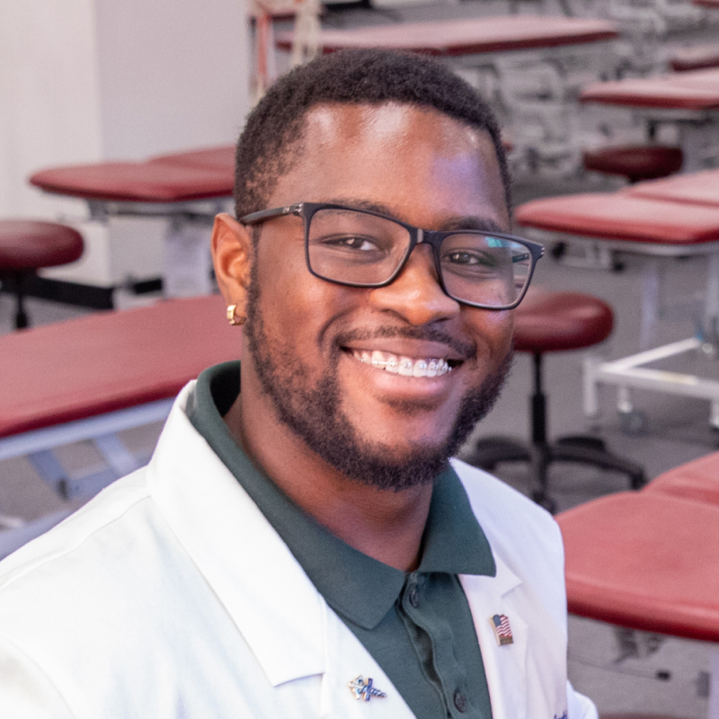 Ronald Lontchi smiling while wearing white coat in classroom