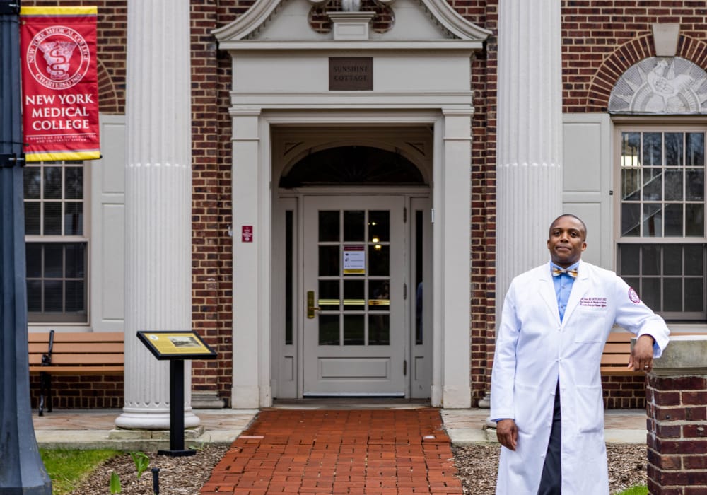 Dr. Mill Etienne standing outside NYMC building